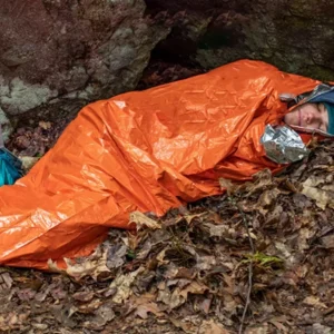 Insulated emergency sleeping bag, reusable & compact w/ whistle. PE material, drawstring. For outdoor & first aid.